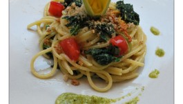 Spaghetti con fiori, foglie e pesto di zucchine, dadini di pomodori e pangrattato piccante